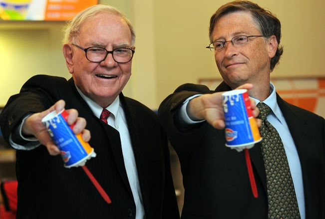 US billionaire investor Warren Buffett (L) and Microsoft founder Bill Gates (R) flip over their Dairy Queen Blizzard treats, the most successful product ever released in the history of Dairy Queen, a US desert chain with over 300 stores in China, at the opening of a new branch in Beijing on September 30, 2010.  Gates and Buffett hosted a banquet the previous night for China's super rich that sparked debate about Chinese philanthropy, amid reports that wealthy invitees had been reluctant to attend. The two, who have already persuaded 40 wealthy US individuals to hand over more than half of their fortunes, had insisted they would not pressure attendees for money and simply wanted to learn about charity in China. Buffett is the CEO of Berkshire Hathaway which owns Dairy Queen. AFP PHOTO/Frederic J. BROWN (Photo credit should read FREDERIC J. BROWN/AFP/Getty Images)