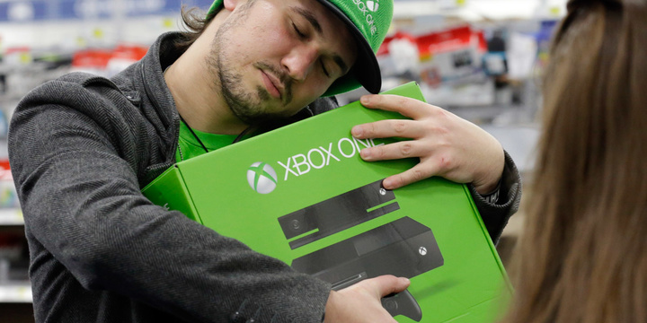 Emanuel Jumatate from Chicago, hugs his newest XBox One after he purchased it at a Best Buy on Friday, Nov. 22, 2013., in Evanston, Ill. The Xbox One, which includes an updated Kinect motion sensor, cost $500. Microsoft is billing it as an all-in-one entertainment system rather than just a gaming console. (AP Photo/Nam Y. Huh)