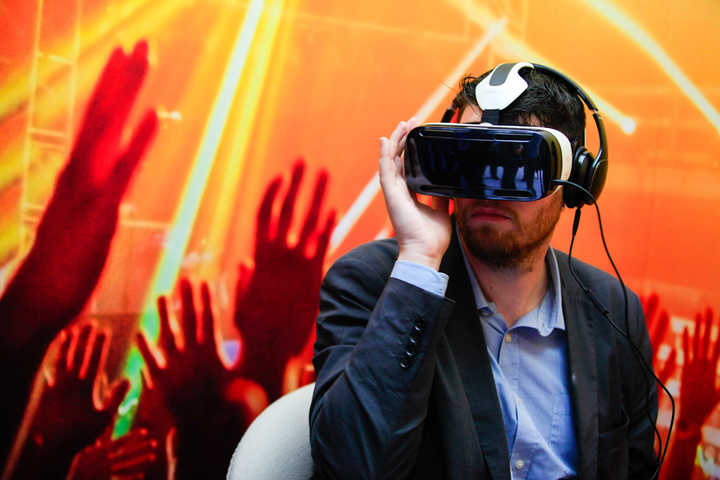 A visitor tests a Samsung Gear VR virtual reality headset, developed jointly by Oculus VR Inc. and Samsung Electronics Co., at the IFA Consumer Electronics Show in Berlin, Germany, on Friday, Sept. 5, 2014. Samsung unveiled its first smartphone with a display extending down one side as it counts on two new versions of its Galaxy Note devices to help fend off Apple Inc.'s push into large-screen mobiles. Photographer: Krizstian Bocsi/Bloomberg