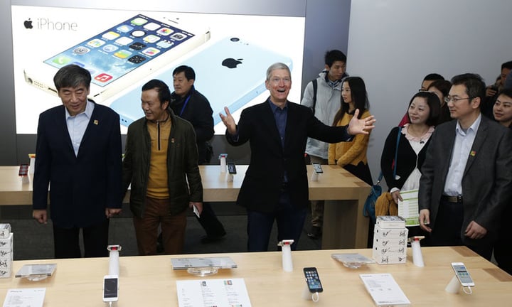Apple Inc. CEO Tim Cook (3rd R) reacts next to China Mobile's Chairman Xi Guohua (L) at an event celebrating the launch of Apple's iPhone on China Mobile's network at a China Mobile shop in Beijing January 17, 2014. Apple Inc is finally launching its iPhone on China Mobile Ltd's vast network on Friday, opening the door to the world's largest carrier's 763 million subscribers and giving its China sales a short-term jolt. REUTERS/Kim Kyung-Hoon (CHINA - Tags: BUSINESS TELECOMS)