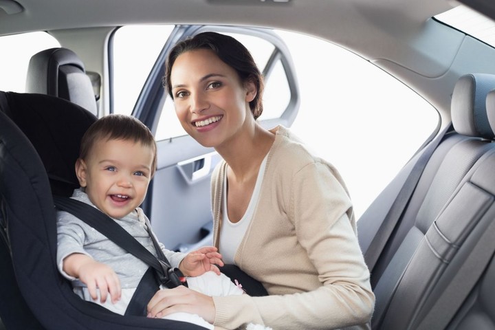 36446810 - mother securing her baby in the car seat in her car