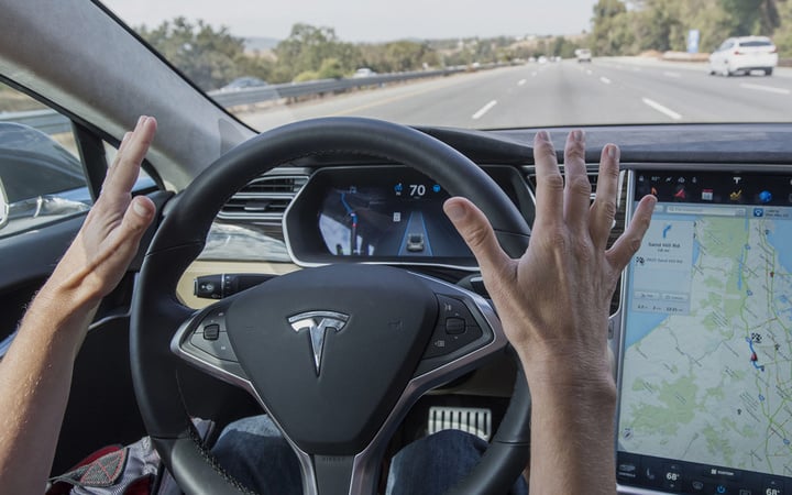 A member of the media test drives a Tesla Motors Inc. Model S car equipped with Autopilot in Palo Alto, California, U.S., on Wednesday, Oct. 14, 2015. Tesla Motors Inc. will begin rolling out the first version of its highly anticipated "autopilot" features to owners of its all-electric Model S sedan Thursday. Autopilot is a step toward the vision of autonomous or self-driving cars, and includes features like automatic lane changing and the ability of the Model S to parallel park for you. Photographer: David Paul Morris/Bloomberg via Getty Images