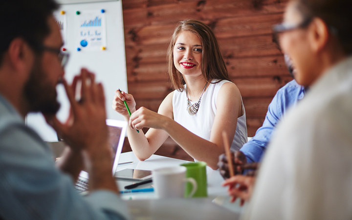 Happy manager looking at colleague during conversation