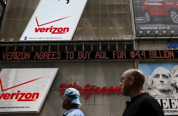 People walk by the Dow Jones electronic ticker at Times Square in New York,