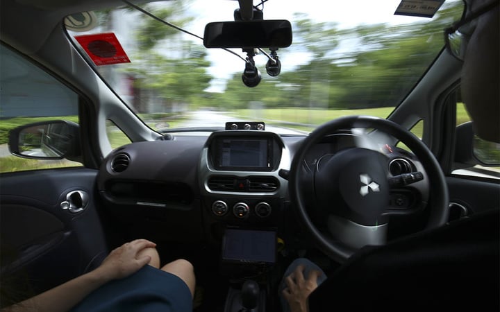 A driver, right, gets his hands off of the steering wheel of an autonomous vehicle during its test drive in Singapore Wednesday, Aug. 24, 2016. The world’s first self-driving taxis, operated by nuTonomy, an autonomous vehicle software startup, will be picking up passengers in Singapore starting Thursday, Aug. 25. The service will start small - six cars now, growing to a dozen by the end of the year. The ultimate goal, say nuTonomy officials, is to have a fully self-driving taxi fleet in Singapore by 2018, which will help sharply cut the number of cars on Singapore’s congested roads. (AP Photo/Yong Teck Lim)