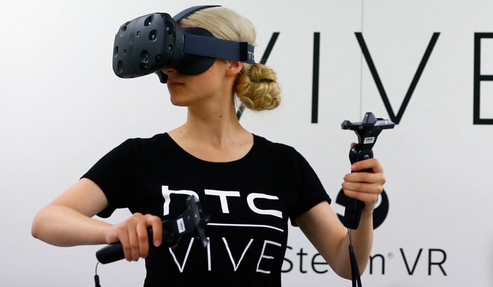 A woman checks a pair of Vive Virtual Reality goggles, produced by Taiwan's HTC, during the Gamescom 2015 fair in Cologne