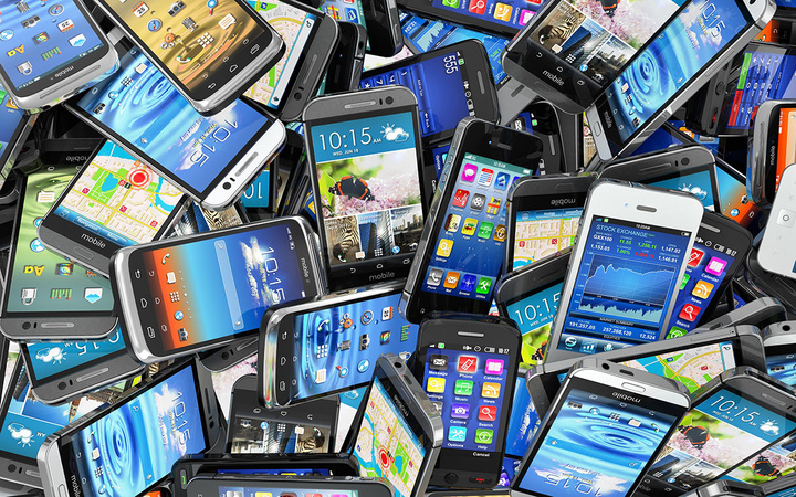 Mobile phones background. Pile of different modern smartphones.