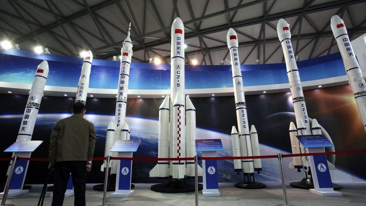 A visitor looks at the scale models of Chinese space roquets displayed at the China International Industry Fair in Shanghai, China, Tuesday, Nov. 5, 2013. (AP Photo/Eugene Hoshiko)