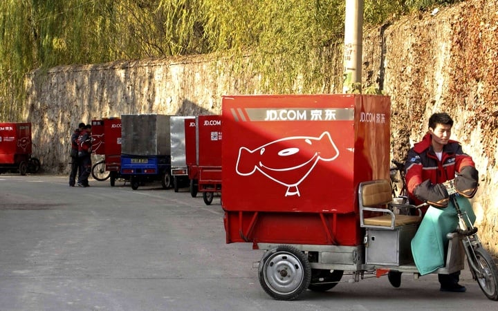 Chen Honglei, a 26-year-old courier of Jingdong, also known as JD.com, prepares his electric tricycle before leaving the company's Haidian district delivery station in Beijing, November 20, 2013. The Beijing-based firm, China's second largest e-commerce company, operates its own network of couriers and warehouses, a factor it says ensures timely and efficient delivery. Larger rivals Tmall and Taobao, the online marketplaces run by mega-firm Alibaba Group Holding Ltd, still depend on merchants and external courier firms for their logistics. Jingdong uses a 10,000-strong fleet of couriers to deliver packages to major locations across China within 24 hours. The company also has 1,400 warehouses nationwide to supply a customer base that accounts for over a sixth of China's 591 million registered Internet users. Picture taken November 20, 2013. REUTERS/Paul Carsten (CHINA - Tags: BUSINESS EMPLOYMENT SCIENCE TECHNOLOGY)