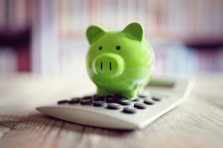 green_piggy_bank_sitting_on_a_calculator_GettyI.original.jpg!720