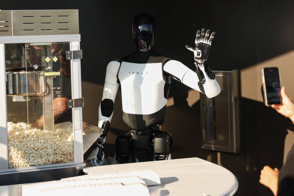 Tesla plant den Bau eines 150.000 Yuan teuren Model Y und reduziert dabei die Konfigurationen, wo immer möglich - tesla optimus robot scoops popcorn and waves at attendees news photo 1753249743